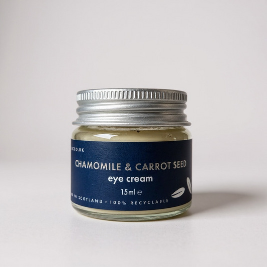 Jar of chamomile and carrot seed eye cream with a blue label on a white background